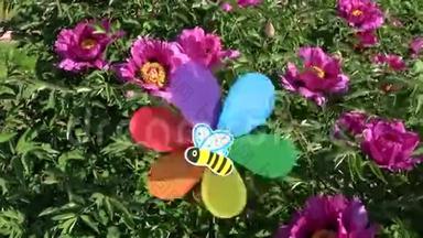 彩虹色装饰风车玩具花园牡丹花丛近风